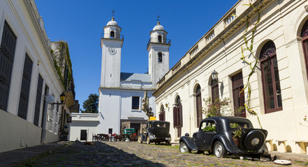 Obsolete cars, in front of the church of Colonia del Sacramento, Uruguay. It is one of the oldest cities in Uruguay. - 287411795