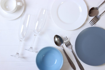 Set of dishes and kitchen utensils on a light background top view.