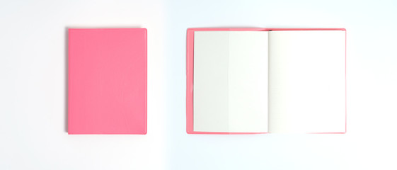 Fototapeta premium Pink notebook on white desk. Business minimal concept for women. Flat lay, top view, copy space