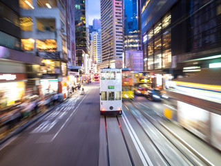 Double Decker Hong Kong Tram also known as Ding Ding at night through city streets. Motion blur.