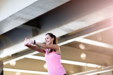 Young woman doing stretching exercise in urban area