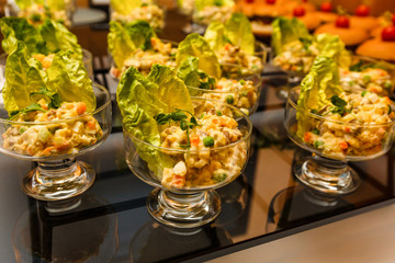 Catering banquet table with vegan vegetarian snacks. Vegetable salad in glass salad bowls. Corporate christmas birthday party event wedding celebration