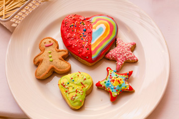 Colorful gingerbread cookies with icing and sprinkles. Tasty cookies in a shape of heart, star, gingerbread man. Birthday party