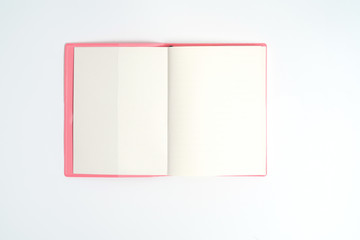 Pink notebook on white desk. Business minimal concept for women. Flat lay, top view, copy space
