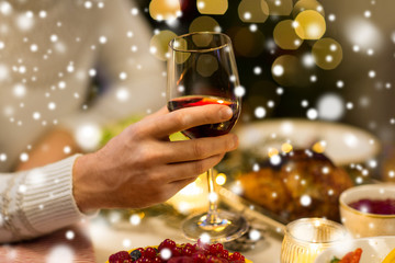 holidays and celebration concept - close up of man having christmas dinner and drinking red wine over snow
