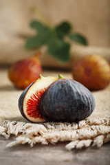 Ripe organic figs on the table. Group of purple and green figs on a farm wooden table with burlap cloth