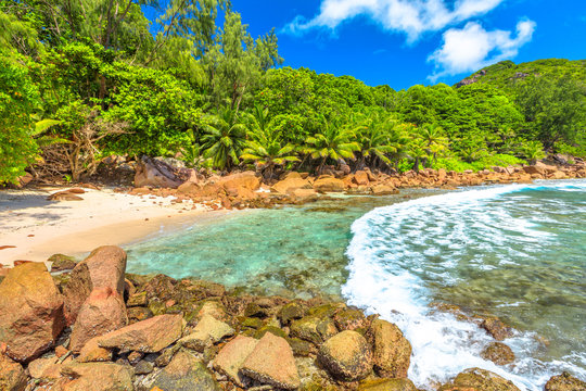 Remote Caiman Beach between Anse Fourmis and Anse Cocos protected by huge rock formations, La Digue, Seychelles