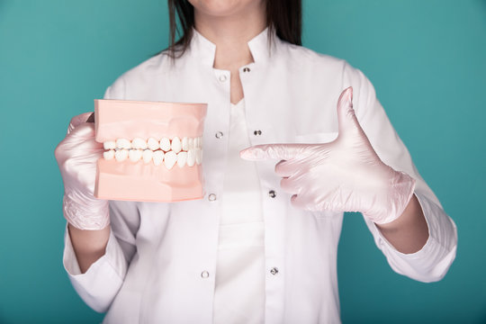 Closeup picture of dentist's hands in uniform holding stuff isolated at th blue background