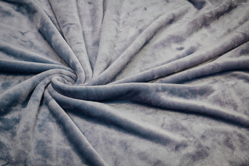 The blanket of furry fleece fabric. A background soft plush fleece material with a lot of relief folds