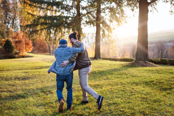 Fototapeta premium Rear view of senior father and his son on walk in nature, running.