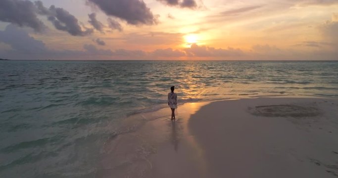 Sunset in the Maldives - A young woman looking at the sea