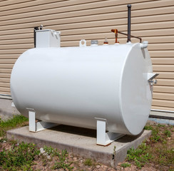 Home fuel tank standing on concrete slab.