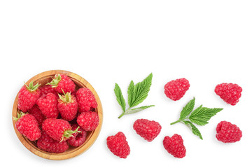 raspberries in wooden bowl with leaves isolated on white background with copy space for your text. Top view. Flat lay pattern