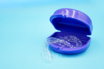 clear plastic retainer teeth in the box set isolated on blue sky background. it's an equipment for orthodontist give the patient to orthodontic surgery in dental clinic or hospital