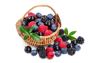 mix of blackberry blueberry raspberry black currant with leaf in wicker basket isolated on white background.