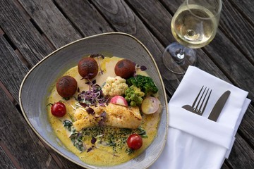 Fisch mit Gemüse, Weinglas und Besteck
