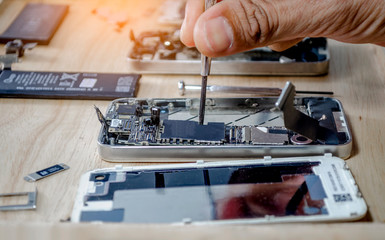 Fototapeta na wymiar Iphone motherboard repairs into the motherboard for smartphone By professional technician on desk
