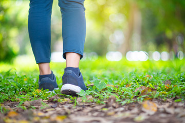 young woman legs walking on forest trail