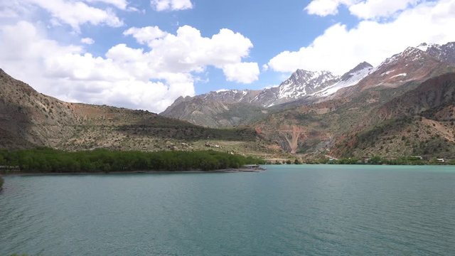 Sughd Iskanderkul Lake Breathtaking Picturesque View with Snow Capped Mountains at Background on a Sunny Blue Sky Day