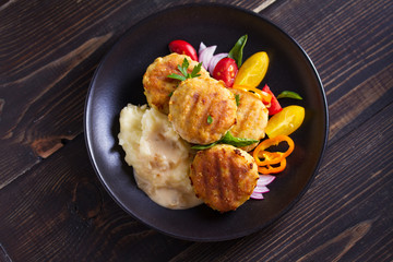 Fish cakes with mashed potatoes and vegetables. Fish patties. Fried cutlets of minced fish. View from above, top studio shot