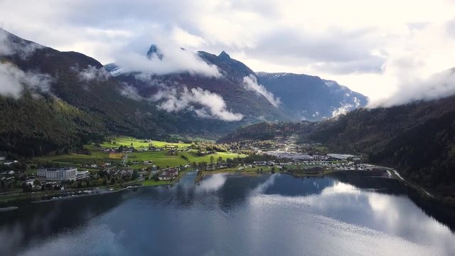 Aerial shot of a small town in the mountain valley, beautiful fjord, Innvikfjorden. SLOW DESCEND