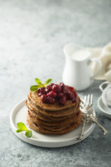 Homemade chocolate pancakes with cherry sauce