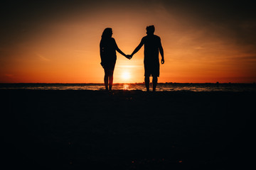 silhouette of couple on beach at sunset