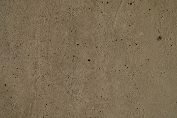 Dark and subdued texture of a cement plaster wall.