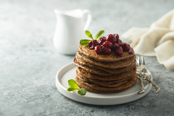 Homemade chocolate pancakes with cherry sauce
