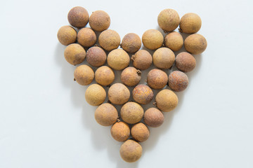Longan arranged in a heart shape on a white background