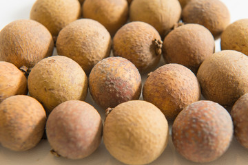 Longan arranged in a heart shape on a white background