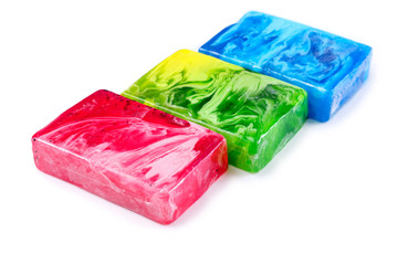 Three multi-colored pieces of handmade soap isolated on white background. Selective focus.