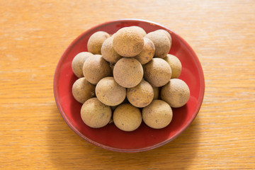 Fresh longan on a red porcelain plate isolated