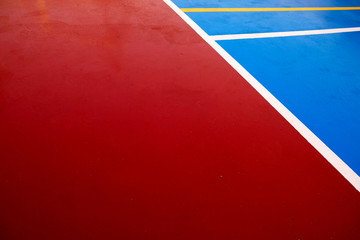 Sports pitch field blue and red surface with curved white touchlines, perspective view.