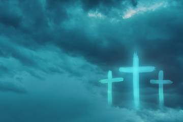 Christian worship and praise. Cloudy sky with three crosses and empty space.