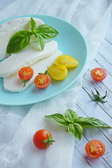 Home-made sliced Adyghe cheese lying on wooden board.