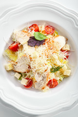 Caesar salad with roasted chicken breast, croutons, cherry tomatoes and grated parmesan cheese