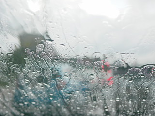 Selective focus of rain on the windshield of a car on a rainy day - driver's perspective