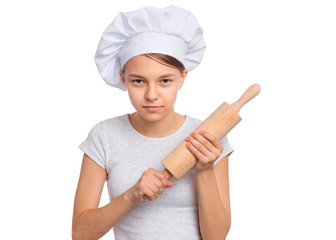 Portrait of beautiful teen girl in chef hat holding rolling pin, isolated on white background. Portrait of cute child cook with wooden rolling pin. Tools and equipment for cooking.
