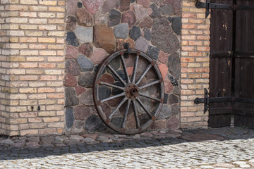 Wagon wheel at the brick wall.