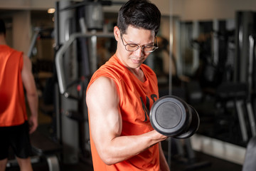 Fototapeta na wymiar Asian man is working out in fitness gym