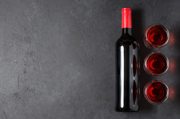 Red wine in glasses. Bottle of wine. Dark background. Copy space