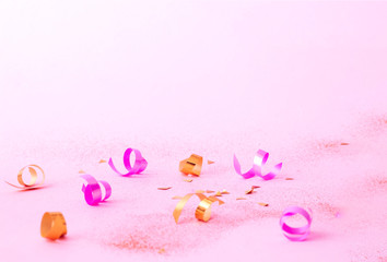 Confetti on pink background with golden sparkles. Concept for festive background or for project