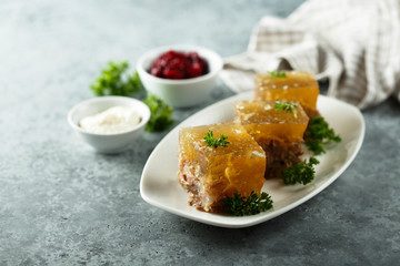 Festive meat jelly with sauces on white plate