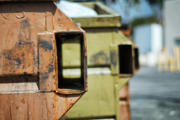 A couple of trash dumpsters in a parking lot.