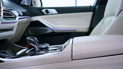 A woman at a car wash does a full dry-cleaning of all parts of a car using special chemistry, cloths, sponges and brushes. Concept of: Full car cleaning, Dry cleaning, Professional service. Car, Work.