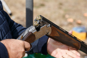 Charging a hunting rifle. Male hunter charges a double-barreled shotgun rounds. Male with a gun,...