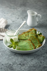 Homemade spinach pancakes with sour cream