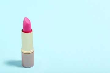 Makeup lipstick on blue background. Minimalism concept