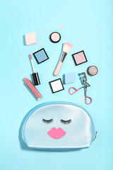 Makeup bag with cosmetics on blue background. Minimalism concept